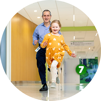 A girl and a Seattle Children's provider run down a hallway at the hospital